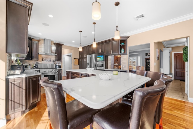 10 Von Trapp Ct, Washingtonville, NY 10992 - kitchen featuring wall chimney exhaust hood, high end appliances, backsplash, dark brown cabinetry, and crown molding