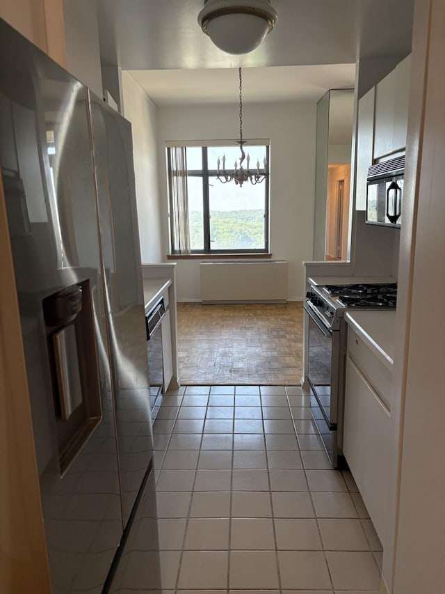112-01 Queens Blvd Unit 20-E, Forest Hills, NY 11375 - kitchen featuring appliances with stainless steel finishes, a chandelier, light countertops, light tile patterned floors, and white cabinetry
