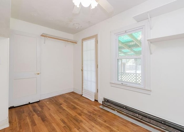 8 Gary Dr, Hyde Park, NY 12538 - unfurnished bedroom featuring a baseboard heating unit, wood finished floors, a closet, and a ceiling fan