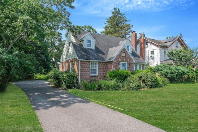 126 Carman St, Patchogue, NY 11772 - view of front of house featuring brick siding, a front yard, and roof with shingles