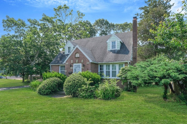 126 Carman St, Patchogue, NY 11772 - view of front of property with brick siding, a front lawn, and a chimney