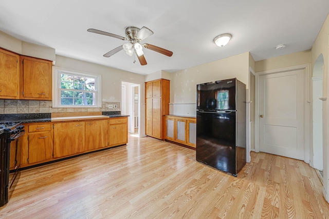 126 Carman St, Patchogue, NY 11772 - kitchen with black appliances, brown cabinetry, light wood-type flooring, and a ceiling fan