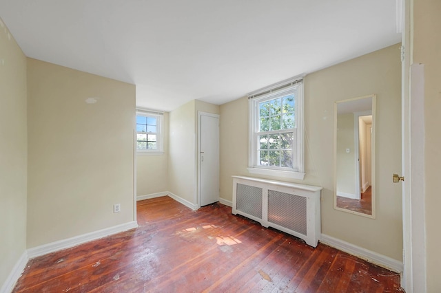 126 Carman St, Patchogue, NY 11772 - unfurnished room featuring radiator, wood-type flooring, and healthy amount of natural light