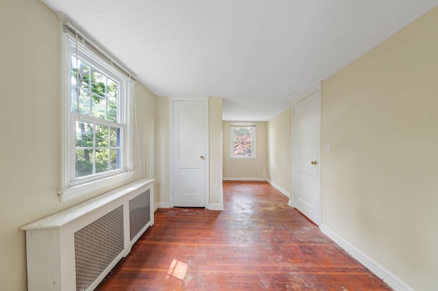 126 Carman St, Patchogue, NY 11772 - empty room featuring radiator heating unit, wood finished floors, and plenty of natural light
