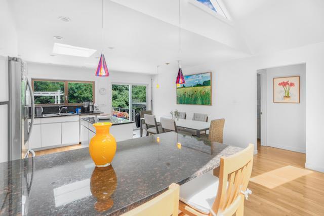 305 Fire Island Blvd, Fire Island Pines, NY 11782 - kitchen featuring freestanding refrigerator, white cabinets, light wood-style flooring, hanging light fixtures, and dark stone countertops