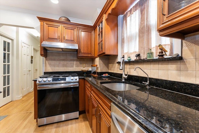1528 Rhinelander Ave, Bronx, NY 10461 - kitchen featuring stainless steel appliances, under cabinet range hood, brown cabinetry, dark stone countertops, and light wood finished floors