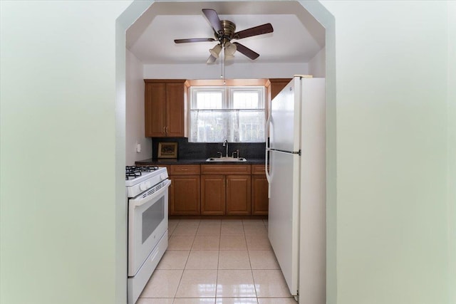 1528 Rhinelander Ave, Bronx, NY 10461 - kitchen with white appliances, dark countertops, light tile patterned floors, ceiling fan, and tasteful backsplash