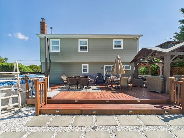 12 Turin St, East Patchogue, NY 11772 - rear view of property featuring outdoor dining space, a chimney, a deck, and a gazebo
