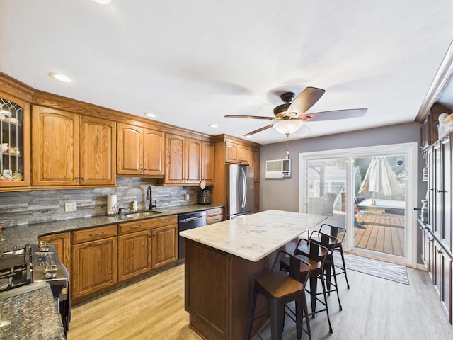12 Turin St, East Patchogue, NY 11772 - kitchen featuring stainless steel appliances, brown cabinets, a breakfast bar area, decorative backsplash, and recessed lighting