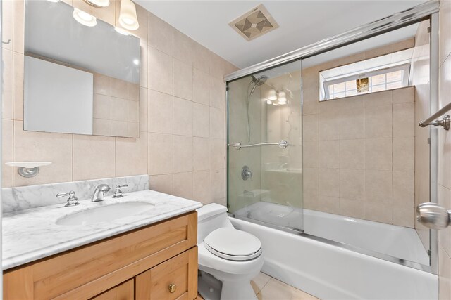 50-55 Cloverdale Blvd, Bayside, NY 11364 - full bathroom with tile walls, vanity, combined bath / shower with glass door, and tile patterned flooring