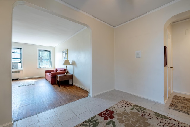 251 Seaman Ave Unit 6A, New York Manhattan, NY 10034 - hall with radiator heating unit, arched walkways, ornamental molding, and light tile patterned flooring