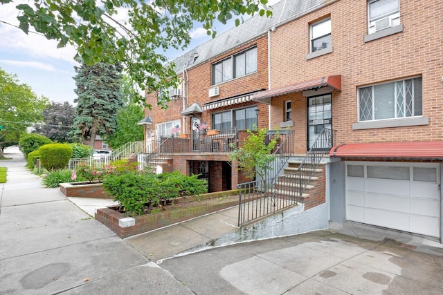 66-48 73rd Pl, Middle Village, NY 11379 - view of front of house featuring brick siding, a garage, concrete driveway, and stairs