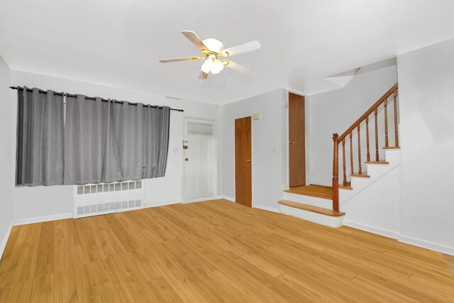 66-48 73rd Pl, Middle Village, NY 11379 - unfurnished room with radiator, wood finished floors, a ceiling fan, and stairway