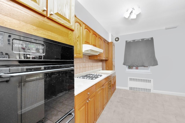 66-48 73rd Pl, Middle Village, NY 11379 - kitchen featuring under cabinet range hood, white gas cooktop, oven, radiator heating unit, and backsplash