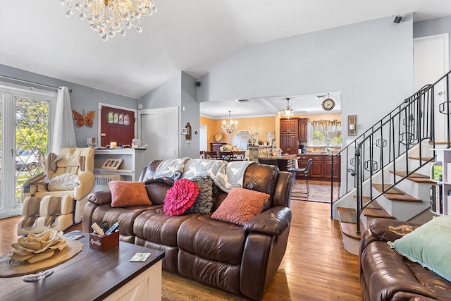 883 Saint James Pl, Franklin Square, NY 11010 - living room featuring a chandelier, vaulted ceiling, light wood-style floors, and stairs