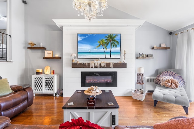 883 Saint James Pl, Franklin Square, NY 11010 - living area featuring wood finished floors, a large fireplace, a chandelier, radiator, and vaulted ceiling