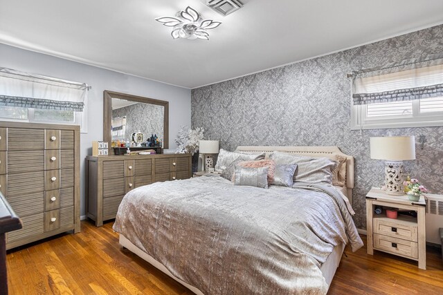 883 Saint James Pl, Franklin Square, NY 11010 - bedroom with wallpapered walls, wood finished floors, and multiple windows
