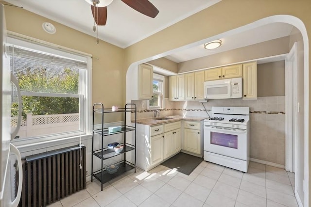 5 Charles St, Valley Stream, NY 11580 - kitchen with white appliances, cream cabinetry, arched walkways, a ceiling fan, and light tile patterned floors