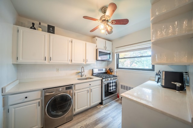 218-12 73rd Ave Unit 401A1, Oakland Gardens, NY 11364 - kitchen featuring washer / dryer, appliances with stainless steel finishes, tasteful backsplash, and white cabinetry