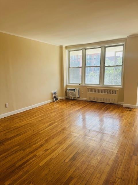 86-05 60th Rd Unit 2E, Elmhurst, NY 11373 - empty room with radiator, hardwood / wood-style floors, healthy amount of natural light, and crown molding