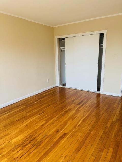 86-05 60th Rd Unit 2E, Elmhurst, NY 11373 - unfurnished bedroom with hardwood / wood-style floors, ornamental molding, and a closet
