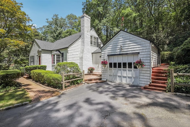 6 Cold Spring Ln, Huntington, NY 11743 - view of front of home with a detached garage, an outdoor structure, a chimney, driveway, and roof with shingles