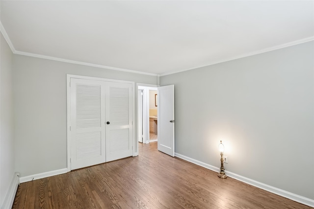 6 Cold Spring Ln, Huntington, NY 11743 - unfurnished bedroom featuring a closet, crown molding, wood finished floors, and a baseboard radiator