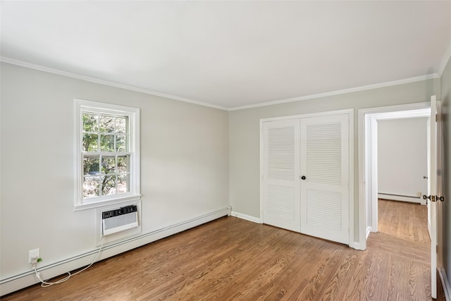 6 Cold Spring Ln, Huntington, NY 11743 - unfurnished bedroom featuring a baseboard radiator, wood finished floors, ornamental molding, and a closet