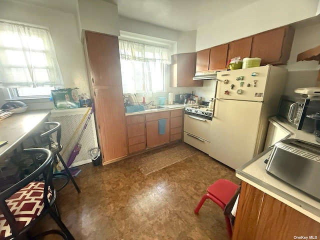 43-67 149th St, Flushing, NY 11355 - kitchen with white appliances, light countertops, dark flooring, under cabinet range hood, and brown cabinets