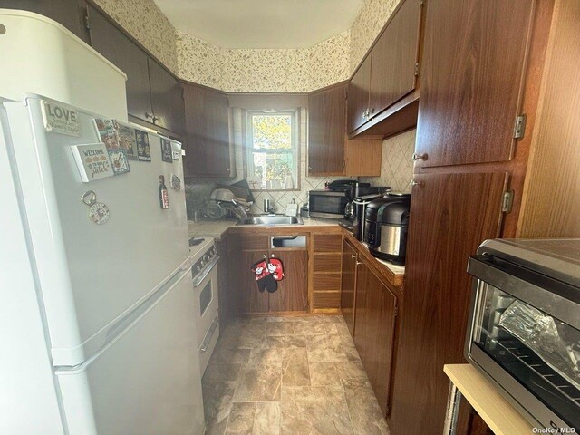 43-67 149th St, Flushing, NY 11355 - kitchen with freestanding refrigerator, decorative backsplash, light countertops, stainless steel microwave, and stone finish floors