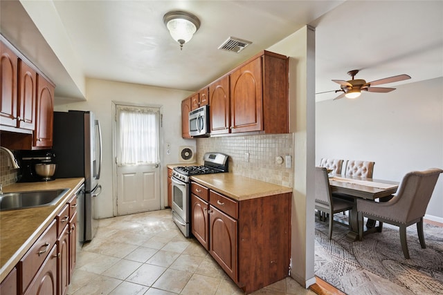 88 E Valley Stream Blvd Unit 7, Valley Stream, NY 11580 - kitchen featuring appliances with stainless steel finishes, decorative backsplash, a ceiling fan, and light tile patterned floors