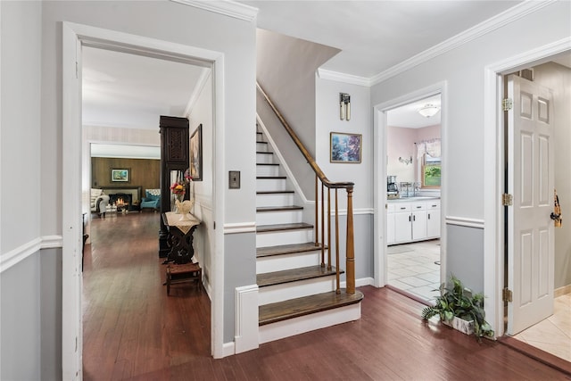 23 Bacon Rd, Head Of The Harbor, NY 11780 - stairway featuring wood finished floors, ornamental molding, and a lit fireplace