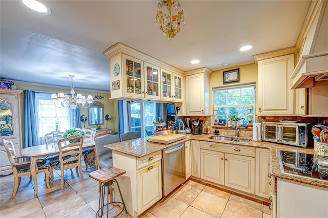 227 Elm St, West Hempstead, NY 11552 - kitchen with dishwasher, cream cabinetry, a chandelier, black electric stovetop, and premium range hood