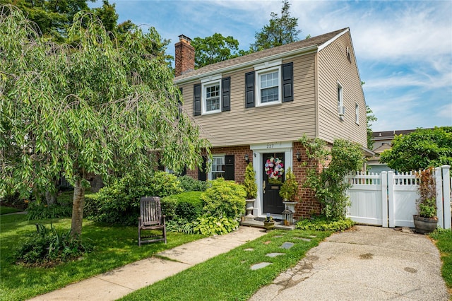 227 Elm St, West Hempstead, NY 11552 - colonial-style house with a chimney and brick siding