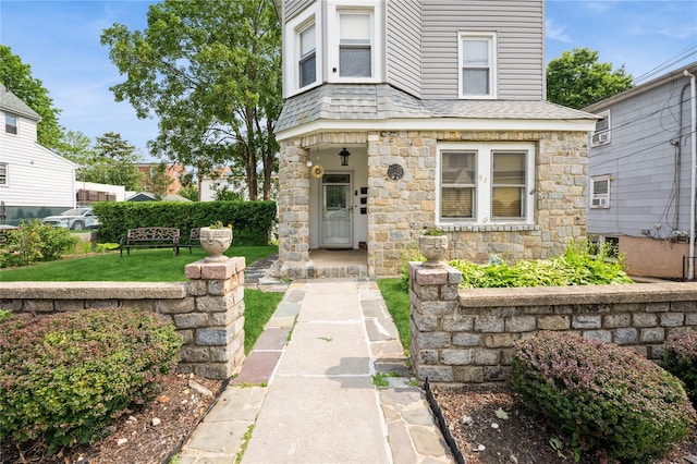 93 Edgewood Ave, Yonkers, NY 10704 - view of front of house featuring stone siding, a shingled roof, and a front lawn