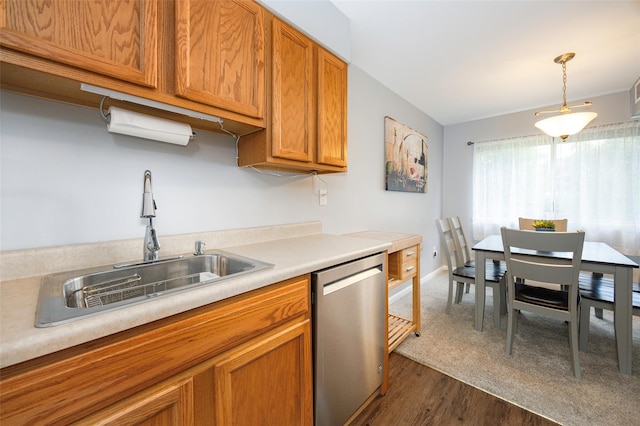 26Cooper Road 307, Poughkeepsie, NY 12603 - kitchen featuring stainless steel dishwasher, light countertops, brown cabinets, hanging light fixtures, and dark wood-style flooring