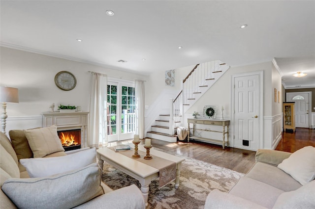 1 Willis Ave, Port Jefferson, NY 11777 - living area with stairway, ornamental molding, wood finished floors, a warm lit fireplace, and recessed lighting