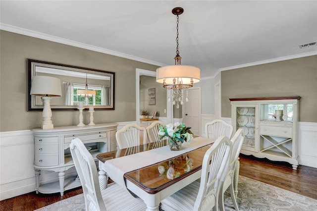 1 Willis Ave, Port Jefferson, NY 11777 - dining space featuring a chandelier, crown molding, wood finished floors, and a wainscoted wall
