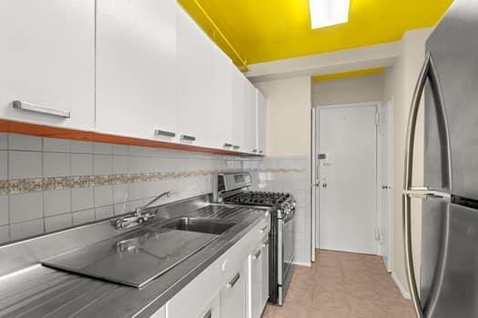 4 Fordham Hill Oval Unit 12B, Bronx, NY 10468 - kitchen featuring appliances with stainless steel finishes, white cabinets, decorative backsplash, and dark countertops