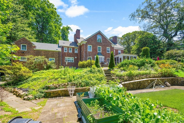 400 Beechmont Dr, New Rochelle, NY 10804 - back of property with a vegetable garden, brick siding, a chimney, and stairway