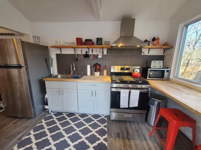 39 E James Ave, Smallwood, NY 12778 - kitchen featuring appliances with stainless steel finishes, wall chimney exhaust hood, open shelves, butcher block countertops, and tasteful backsplash