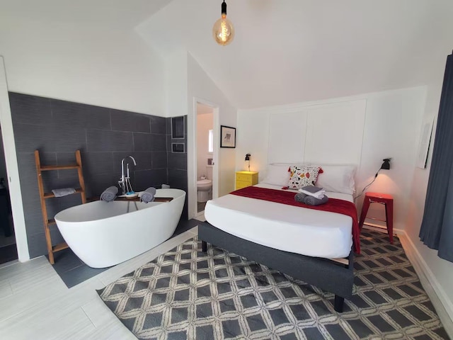 39 E James Ave, Smallwood, NY 12778 - bedroom featuring lofted ceiling, ensuite bath, and tile walls