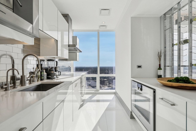 5 Renaissance Sq Unit Ph41G, White Plains, NY 10601 - kitchen with modern cabinets, wine cooler, white cabinets, tasteful backsplash, and light countertops