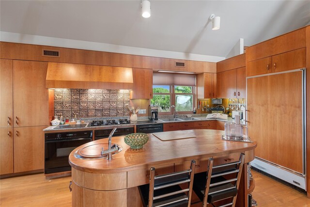 56 Tuthill Point Rd, East Moriches, NY 11940 - kitchen featuring black appliances, brown cabinetry, lofted ceiling, decorative backsplash, and light wood-style floors