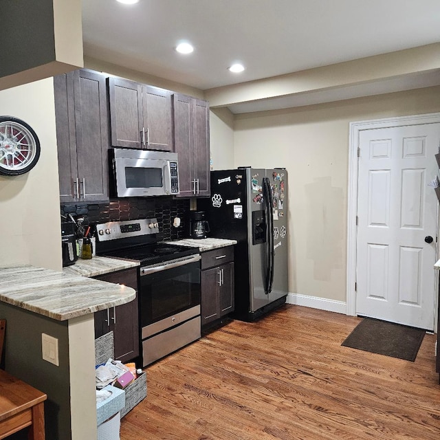 15 Wilmar Ter, Poughkeepsie, NY 12601 - kitchen with appliances with stainless steel finishes, light wood-style floors, tasteful backsplash, recessed lighting, and light stone counters