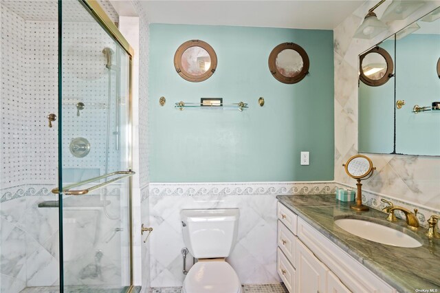 174 Dune Rd, Quogue, NY 11959 - bathroom with a stall shower, tile walls, vanity, and wainscoting