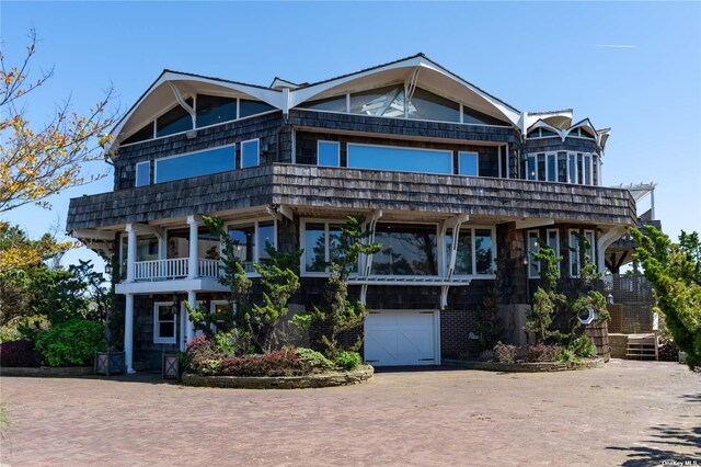 174 Dune Rd, Quogue, NY 11959 - view of front of property with decorative driveway, a garage, and a balcony