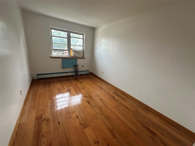 9444 45th Ave, Elmhurst, NY 11373 - empty room featuring a baseboard heating unit and hardwood / wood-style floors