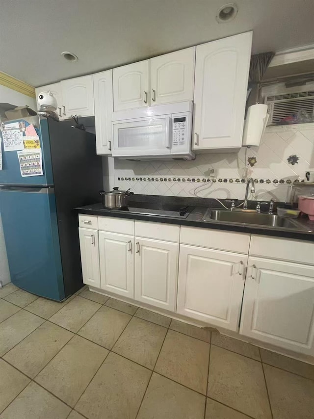 103-23 51st Ave, Corona, NY 11368 - kitchen with white microwave, freestanding refrigerator, dark countertops, backsplash, and light tile patterned floors