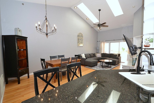 1405 Constance Ln, Port Jefferson Station, NY 11776 - dining space featuring high vaulted ceiling, light wood finished floors, a skylight, and a chandelier